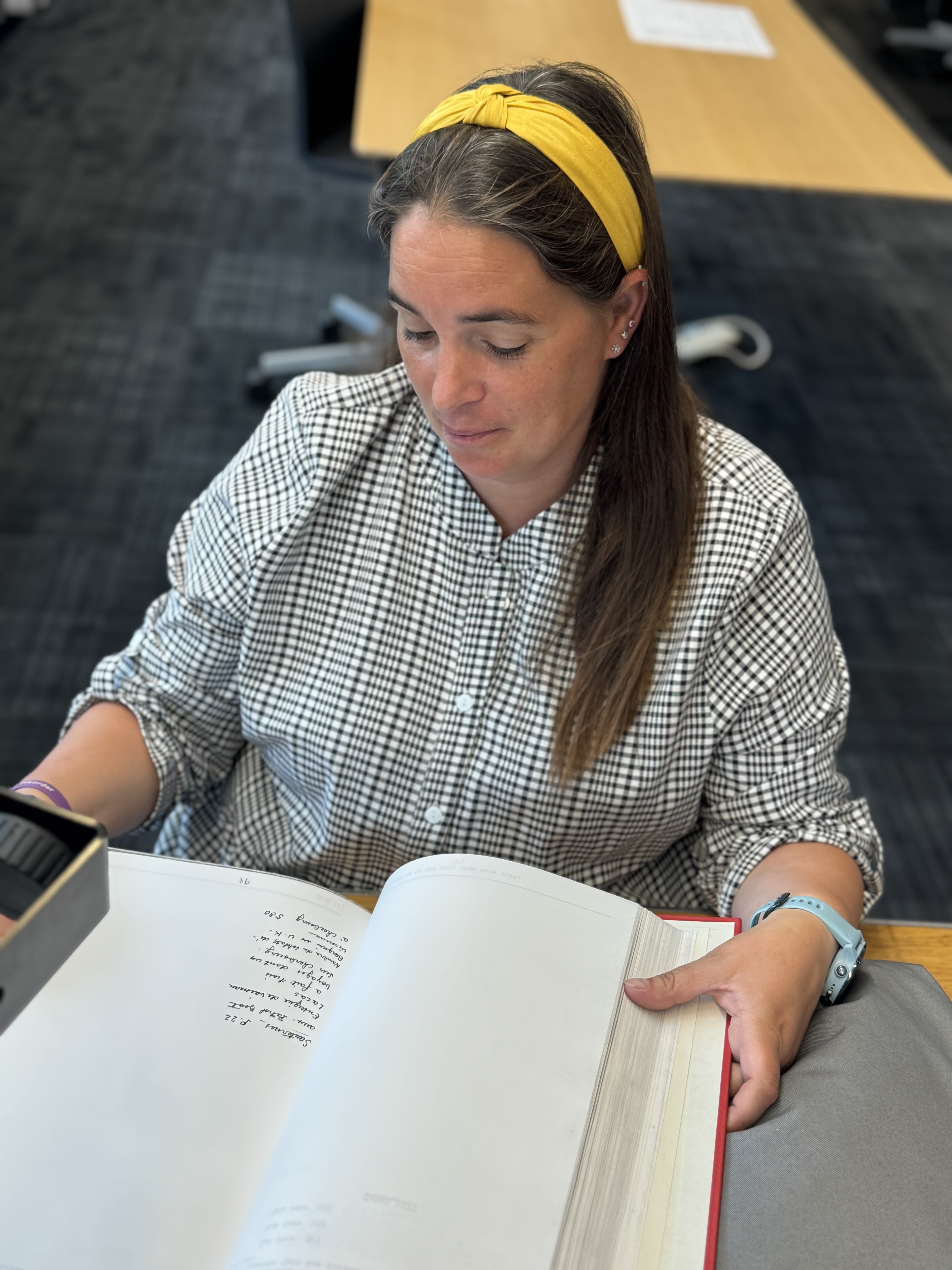 Archivist examining wartime maritime documents.